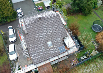 Haus aus der Vogelperspektive mit Gerüst, bevor Solarpanels installiert werden.