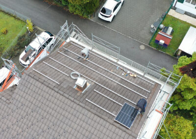 Mathias Grässl und Martin Salzmann von Soleis AG installieren ein Solarpanel auf einem Schrägdach.