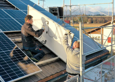 Mathias Grässl und Martin Salzmann von Soleis AG installieren ein Solarpanel auf einem Schrägdach