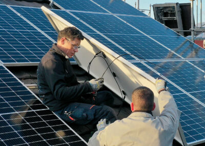 Mathias Grässl und Martin Salzmann von Soleis AG installieren ein Solarpanel auf einem Schrägdach